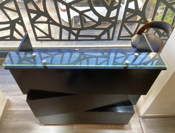 counter negro con tope de cristal con luces con gaveta butaca y area