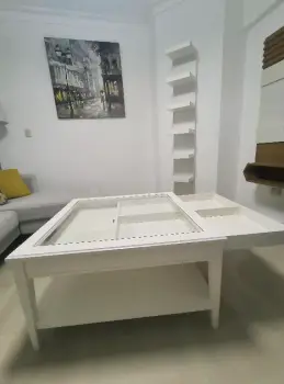Mesa de centro color blanco  con gavetas y cristal.
